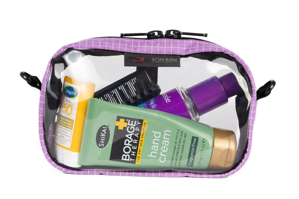 A Sakura (lavender with white grid pattern) Halcyon 3D Clear Organizer Cube filled with sundries.